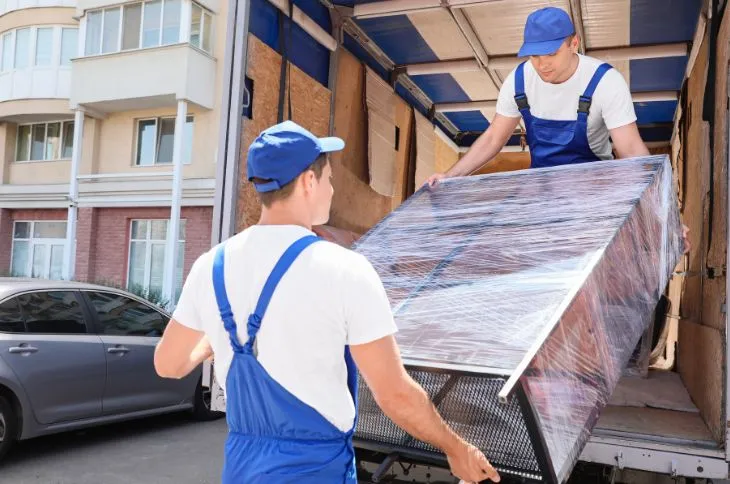 Umzugshelfer beladen ein verpacktes Regal Umzugshelfer beladen ein verpacktes Regal